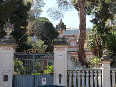 La residenza e il suo ampio giardino sono racchiusi da una lunga balaustra bianca e un raffinato cancello in parte dorato: quest'ultimo � incastrato tra due colonne sormontate da sculture consistenti in vasi di pietra colmi di pigne